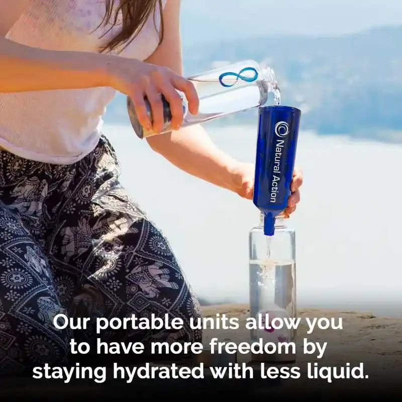 Person pouring water into a blue 'Natural Action' Portable unit into a glass with a scenic background.